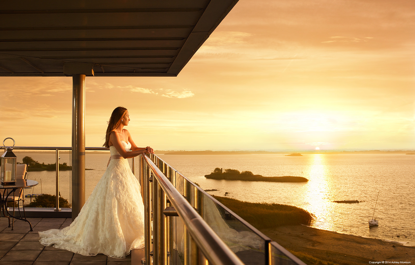 Bride standing in the balcony of Penthouse suite at the Hodson Bay Hotel near Athlone in Ireland.